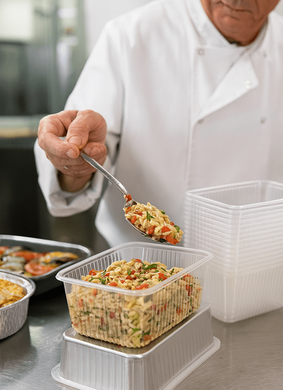 Barquette Pratipack 1500 ml en PP en action chez un traiteur, remplissage de plats pour livraison et restauration à emporter