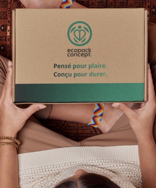 Personne tenant une boîte kraft Ecopack Concept avec le slogan “Pensé pour plaire, conçu pour durer”, packaging éco-responsable. Emballage carton personnalisé. Personnalisation.